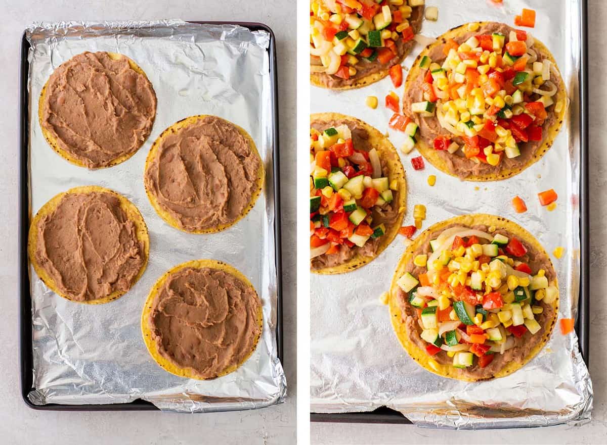 Four corn tortillas on a baking sheet topped with refried beans and sautéed vegetables.