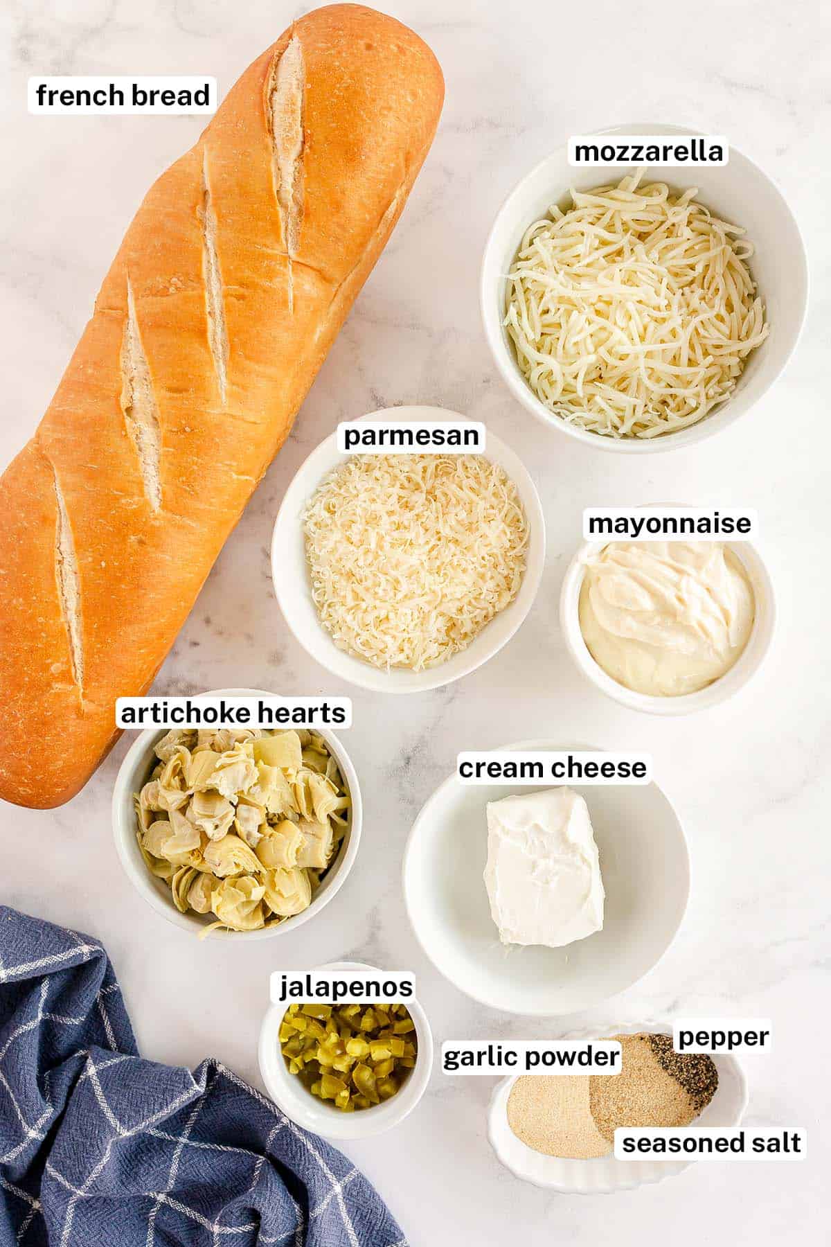 The ingredients for Cheesy Artichoke Bread with overlay text.