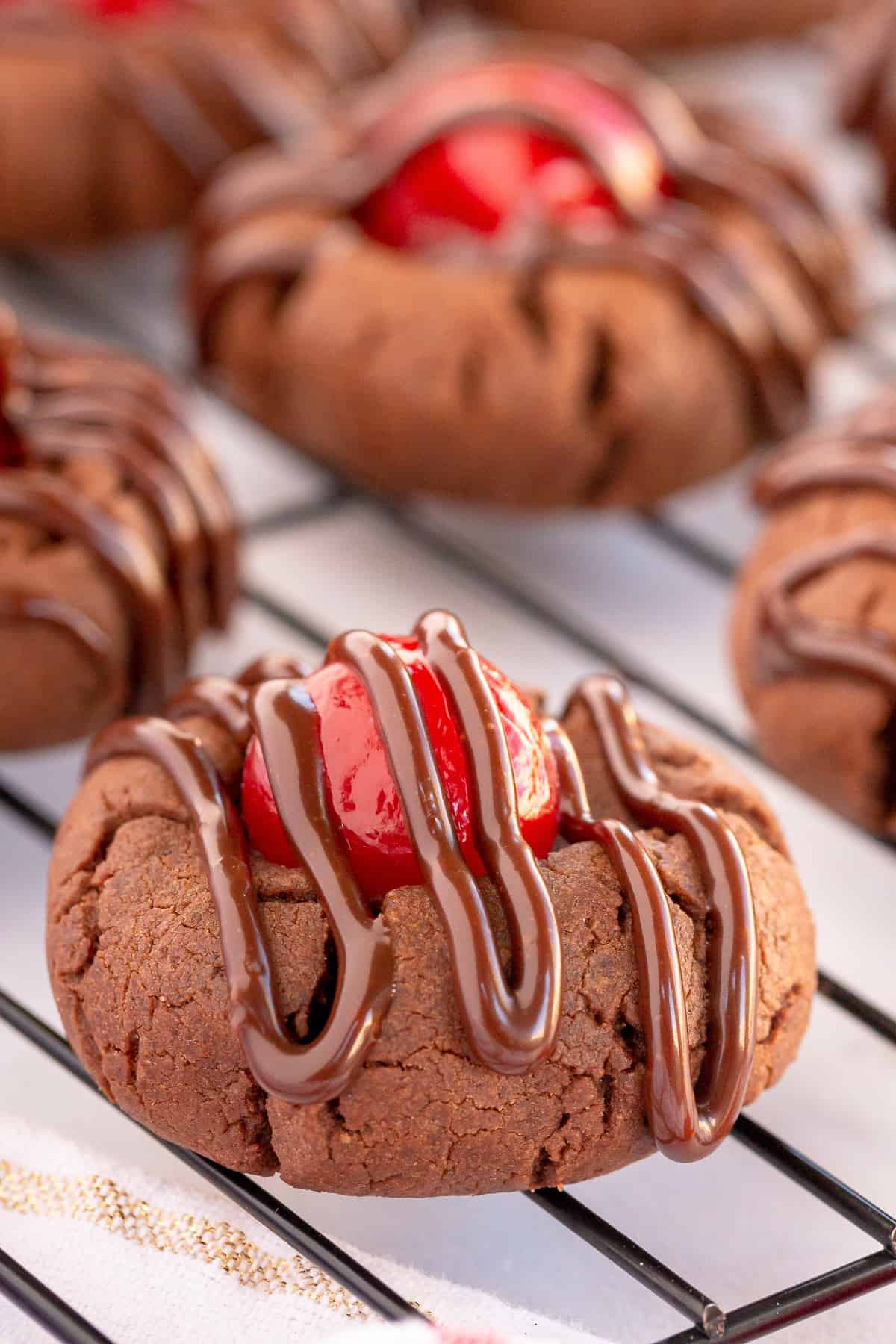 A close up of a Chocolate Covered Cherry Cookie on a wire rack.