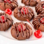 Chocolate Covered Cherry Cookies on a white plate with maraschino cherries.