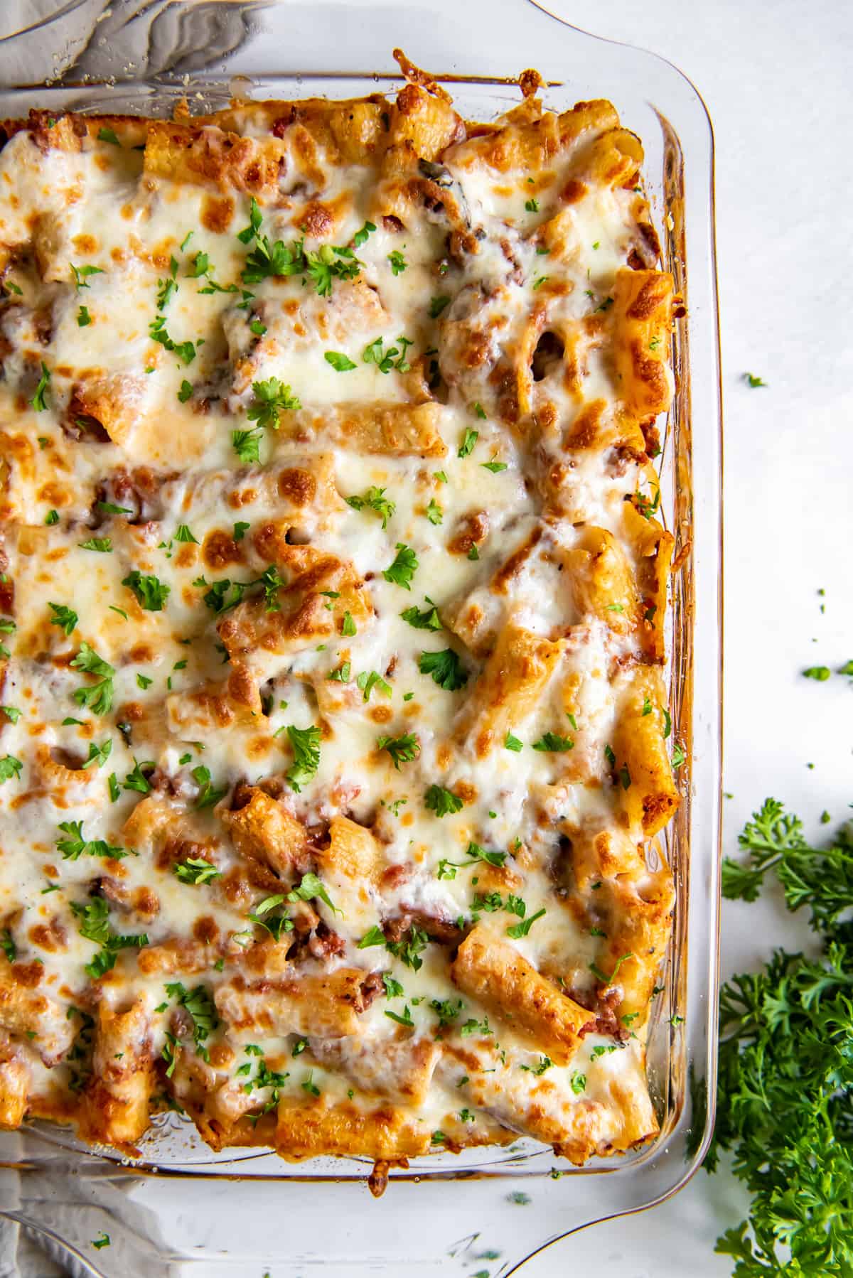 A close up over the top shot of baked rigatoni with meat sauce.