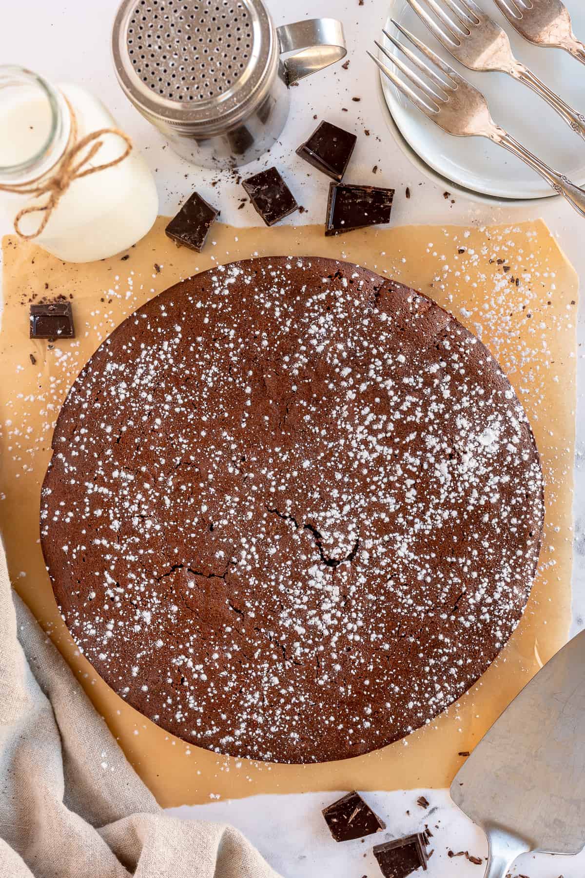 An over the top shot of a French Chocolate Cake dusted with powdered sugar.