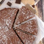 A spatula tucked under a slice of French Chocolate Cake.