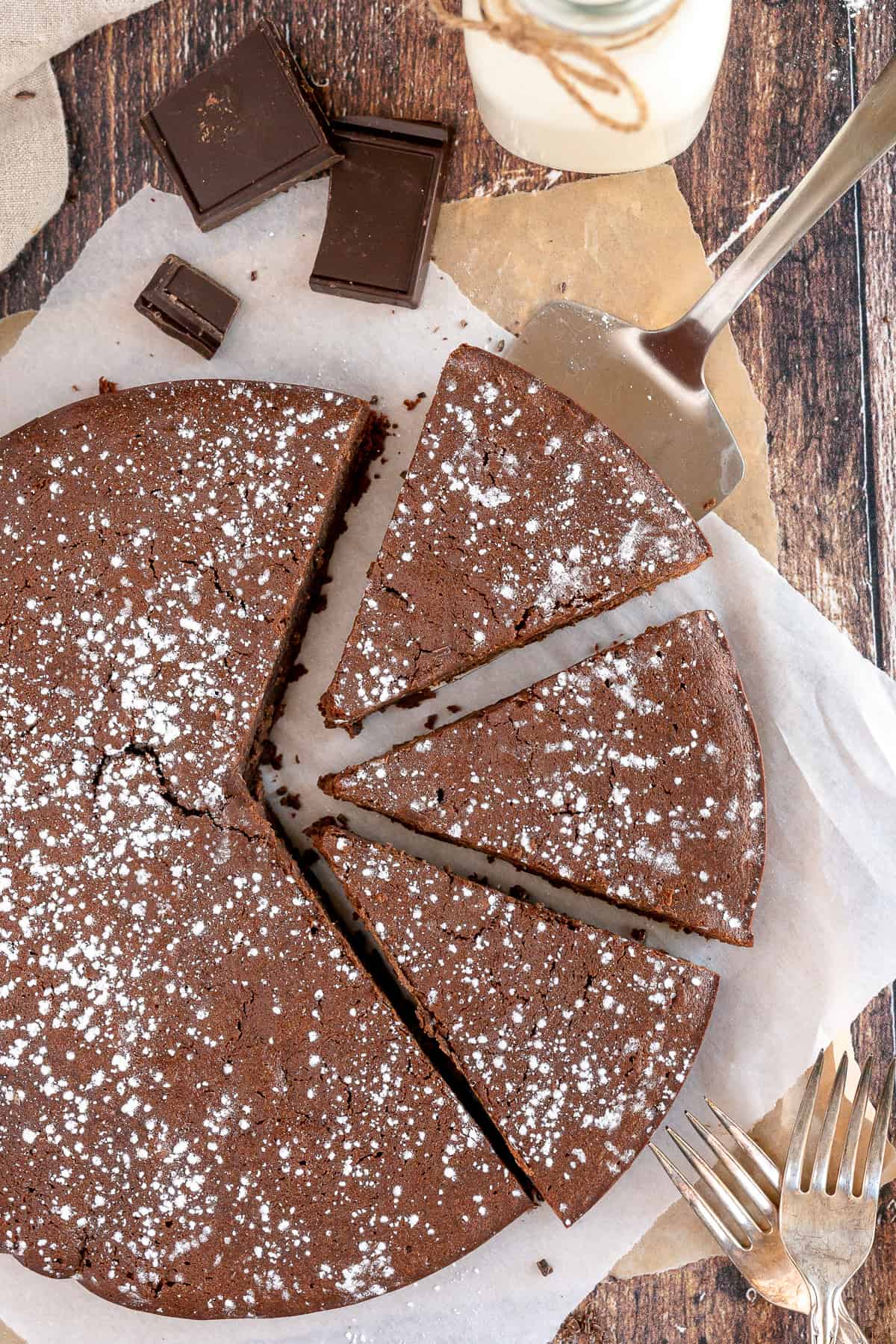 A spatula tucked under a slice of French Chocolate Cake.