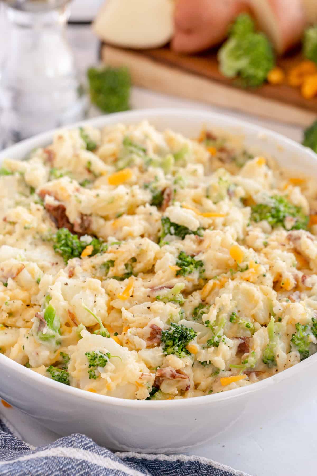 Broccoli cheese mashed potatoes in a white bowl.