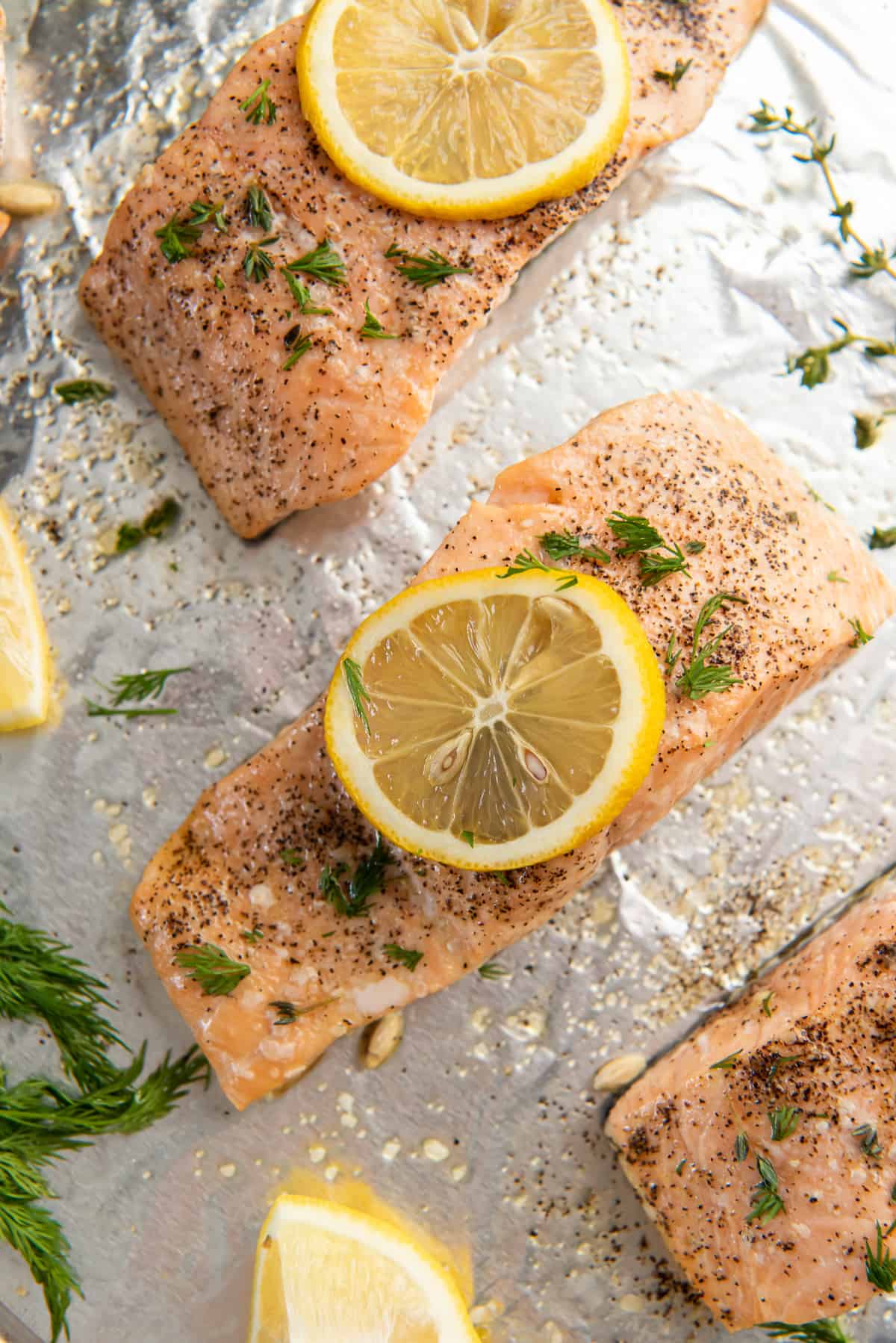 Baked salmon on a baking sheet with lemon and dill.