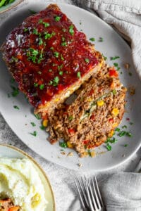 An over the top shot of a sliced meatloaf on a platter.