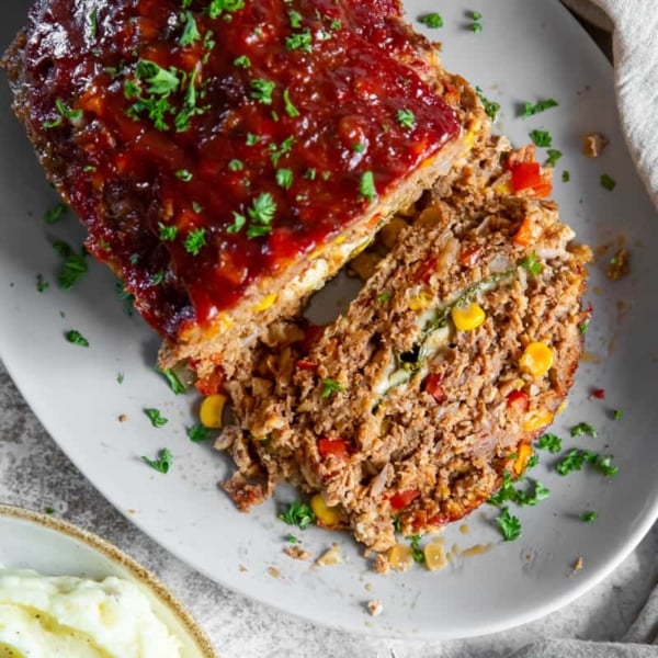 An over the top shot of a sliced meatloaf on a platter.