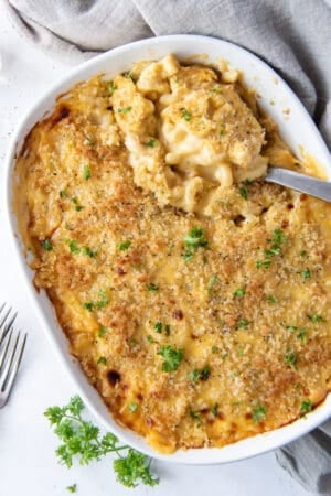 A top down shot of macaroni cheese in a casserole dish with a spoon.