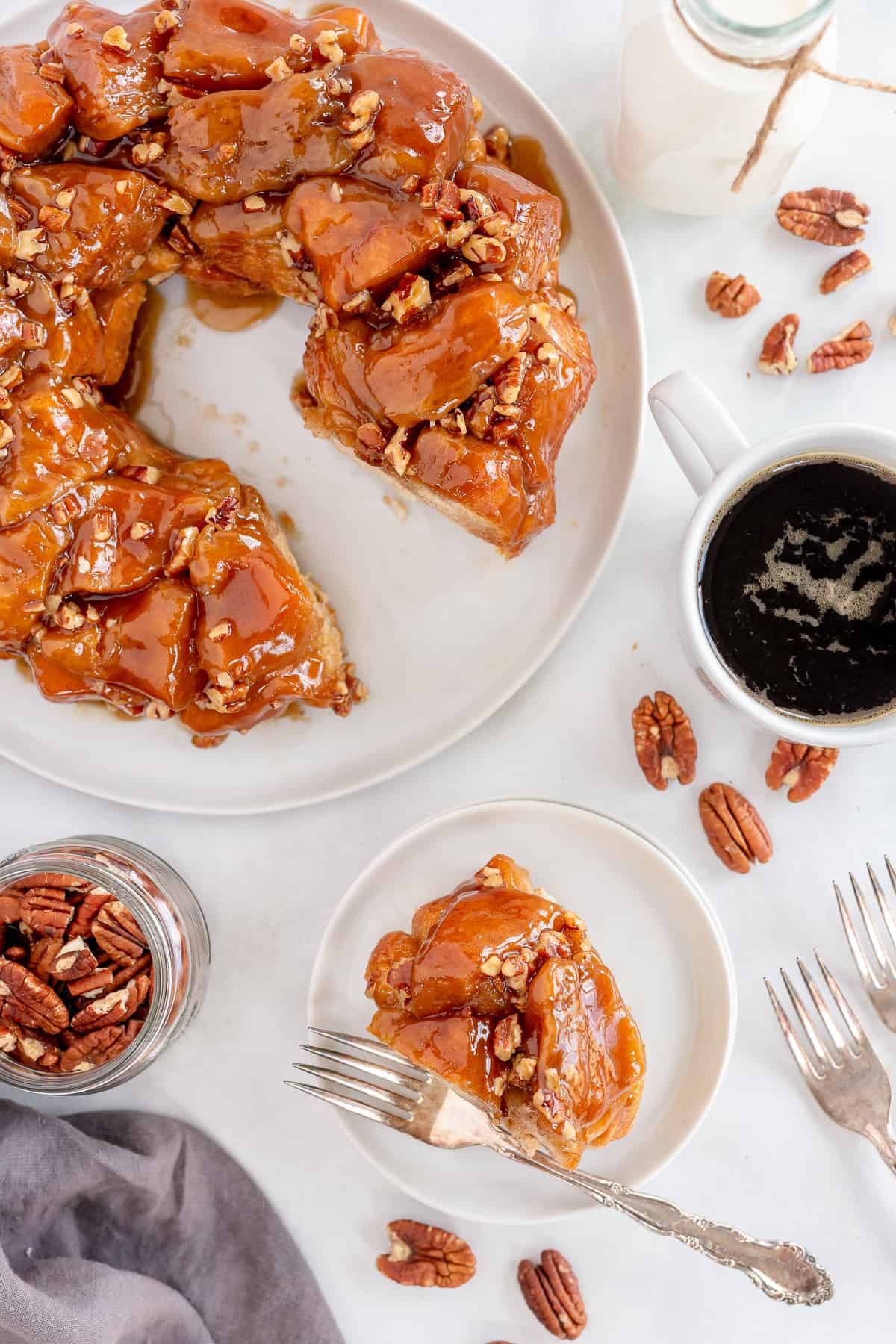 A top down shot of Maple Pecan Monkey Bread on a platter and plate with coffee.