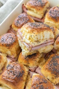 Ham and cheese sliders in a white baking dish.