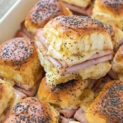 Ham and cheese sliders in a white baking dish.