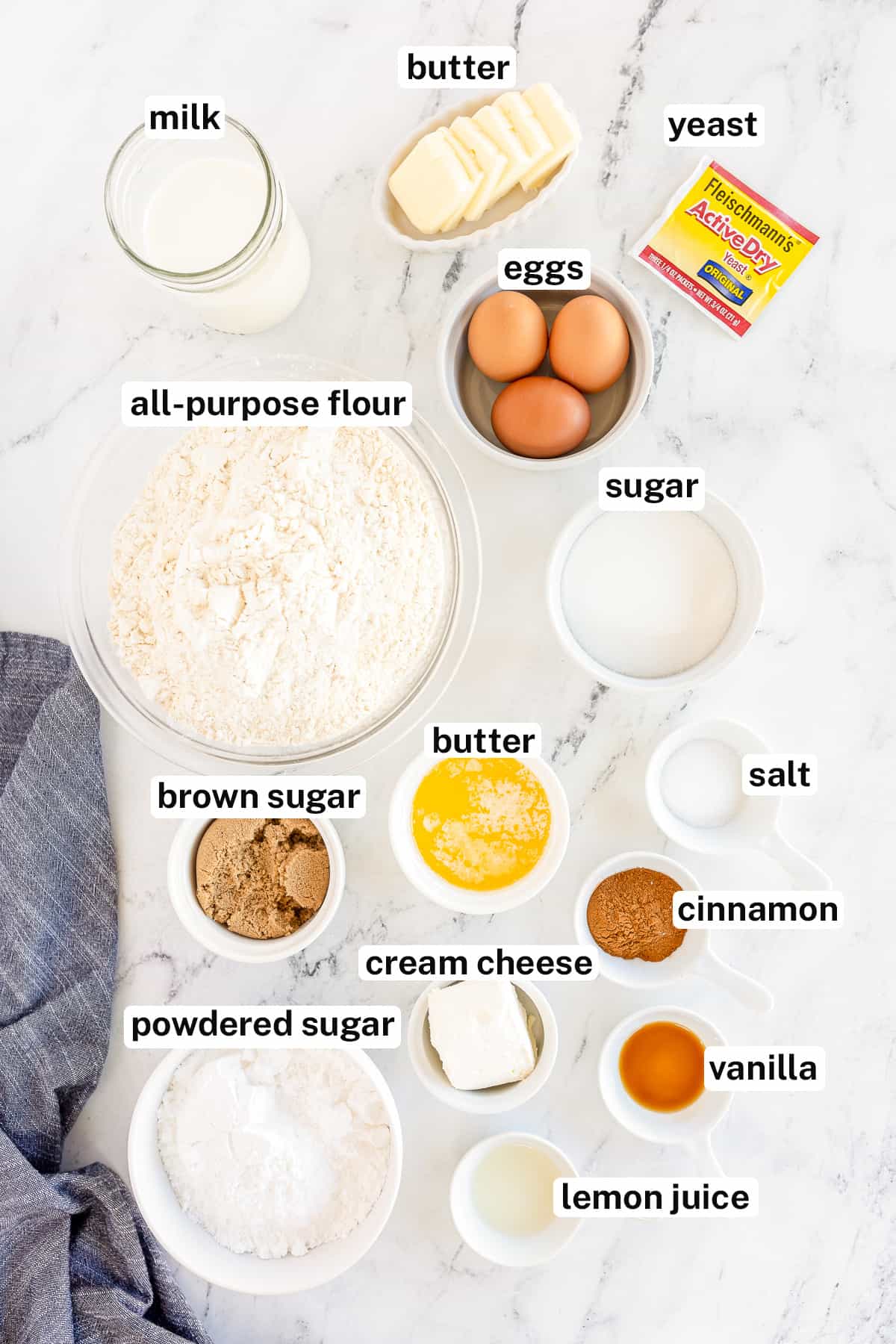 The ingredients for cinnamon rolls and cream cheese frosting with text.