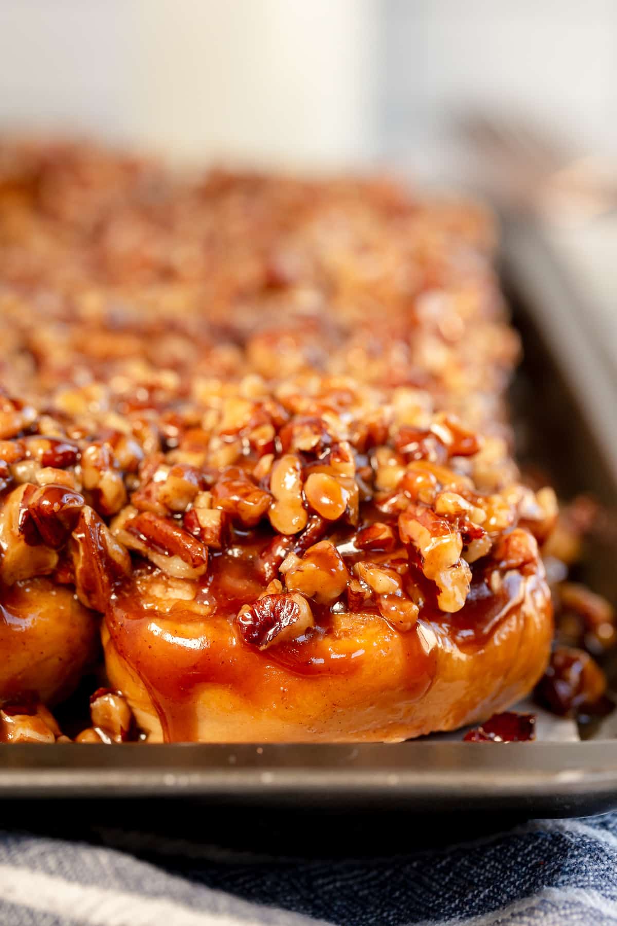 A close up of a sticky bun on a metal baking sheet.