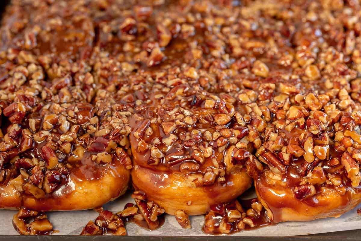 Sticky buns with pecans on parchment paper.