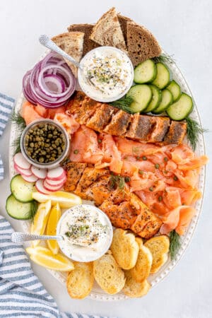 A top down shot of a smoked salmon platter with cream cheese spread and crostini.