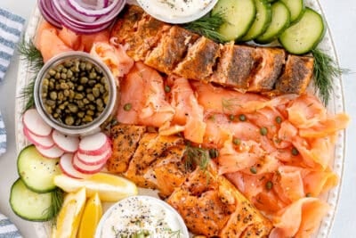 A top down shot of a smoked salmon platter with cream cheese spread and crostini.