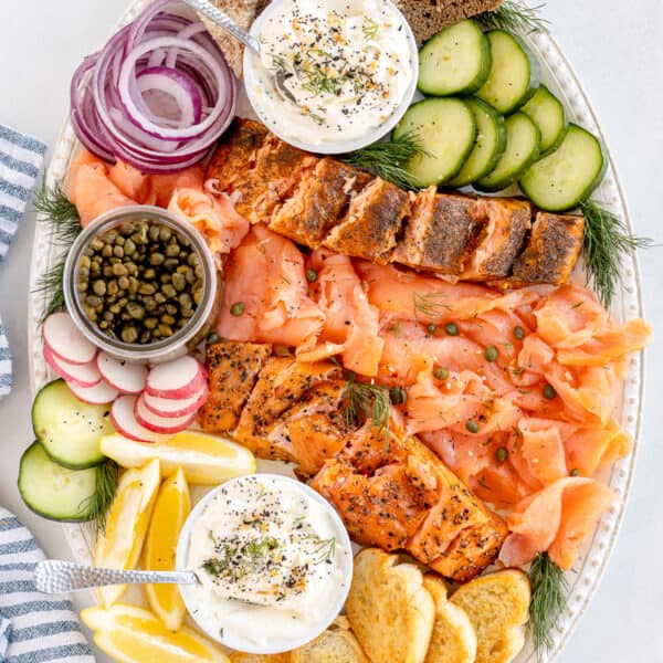 A top down shot of a smoked salmon platter with cream cheese spread and crostini.