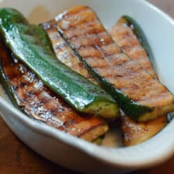 Grilled zucchini in a white dish.