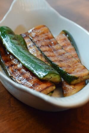 Grilled zucchini in a white dish.