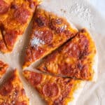 Slices pf pepperoni pizza on parchment paper.