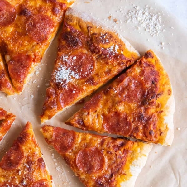 Slices pf pepperoni pizza on parchment paper.