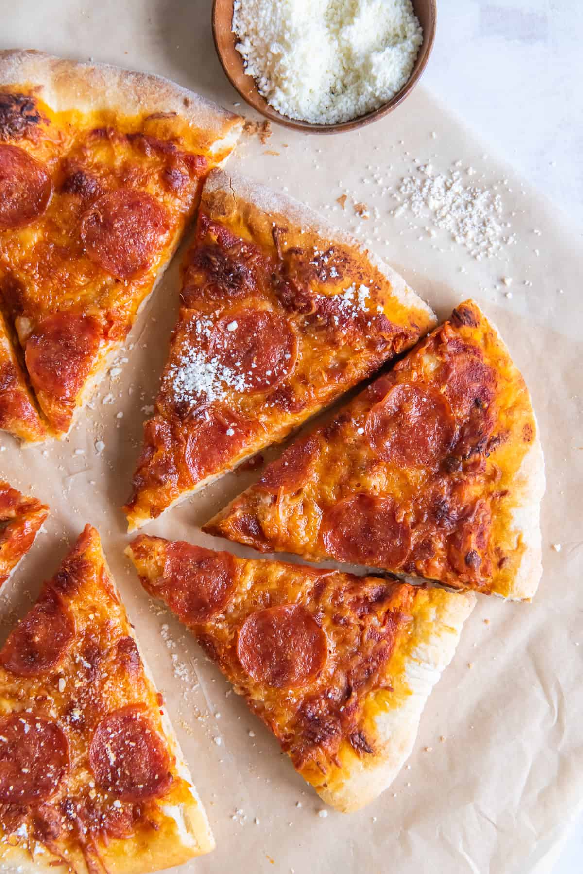 Slices pf pepperoni pizza on parchment paper.