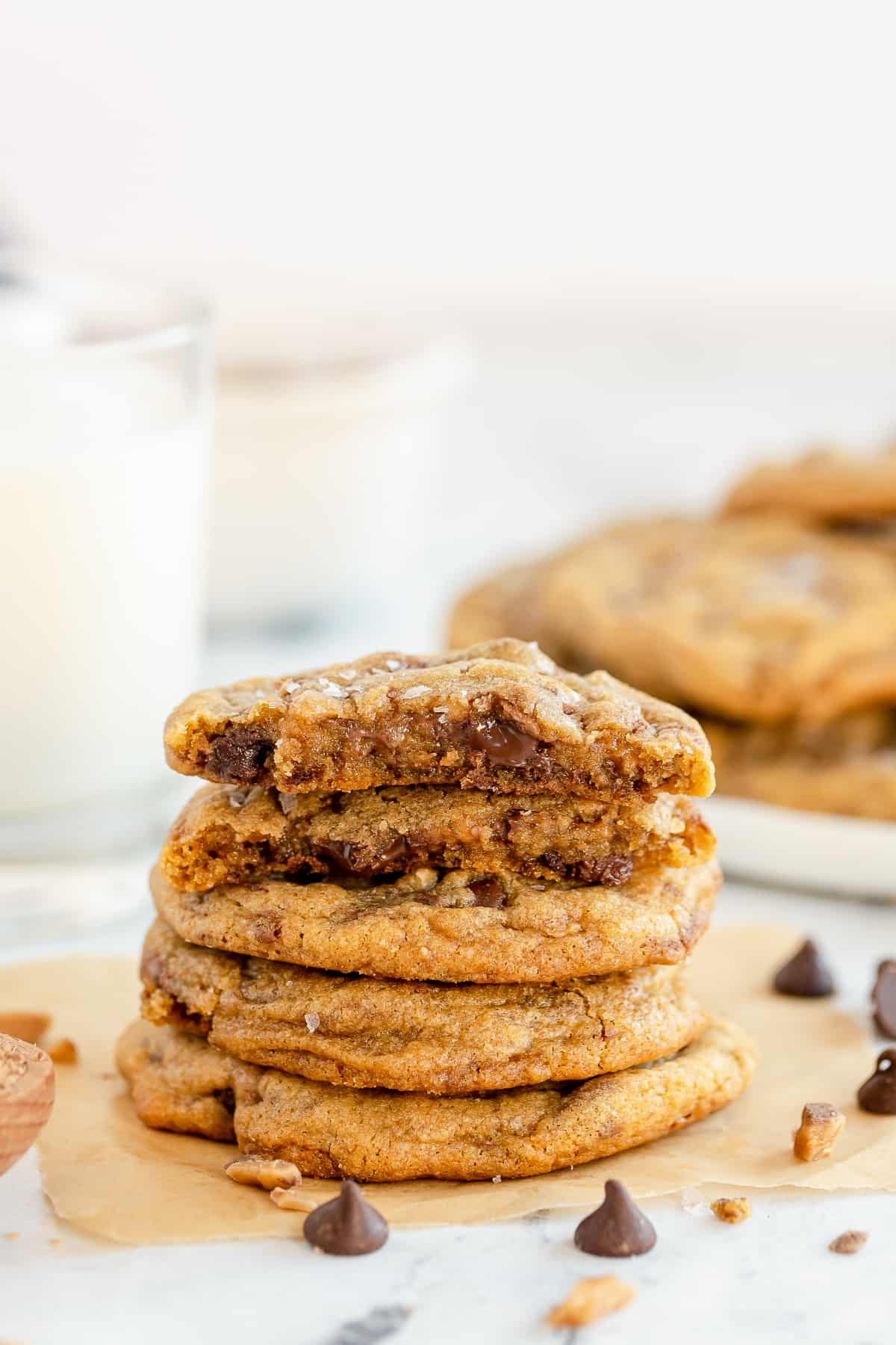 A stack of Toffee Chocolate Chip Cookies on parchment paper.