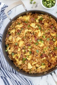 A top down shot of a skillet of fried rice with bacon and egg.