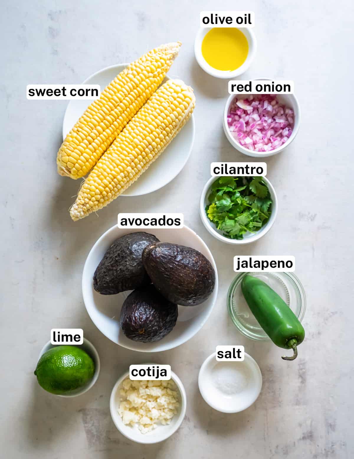 Corn on the cob and other ingredients for corn guacamole with text.