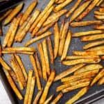 French fries on a rimmed baking sheet.