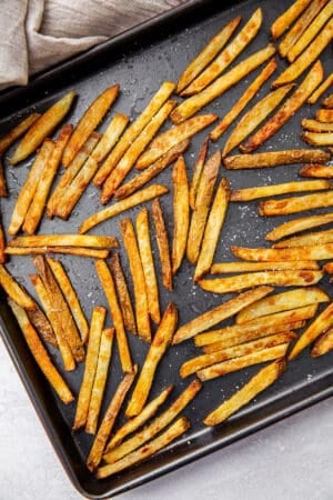 French fries on a rimmed baking sheet.