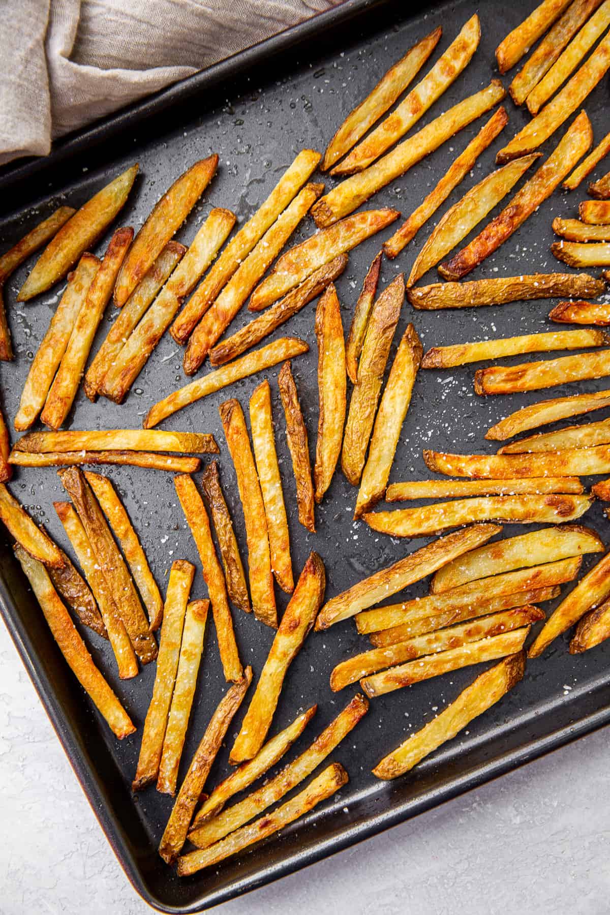 French fries on a rimmed baking sheet.