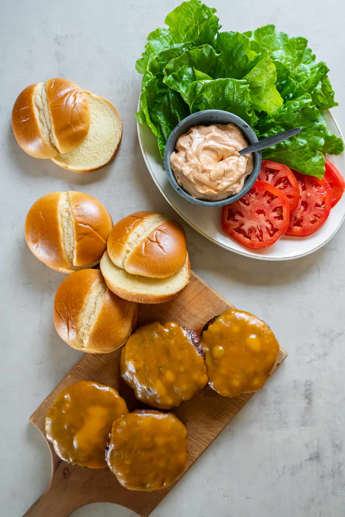 Burger patties with melted cheese, brioche buns, and burger toppings.