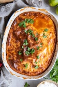 A top down shot of a browned cornmeal crust on tamale pie in a white casserole dish.