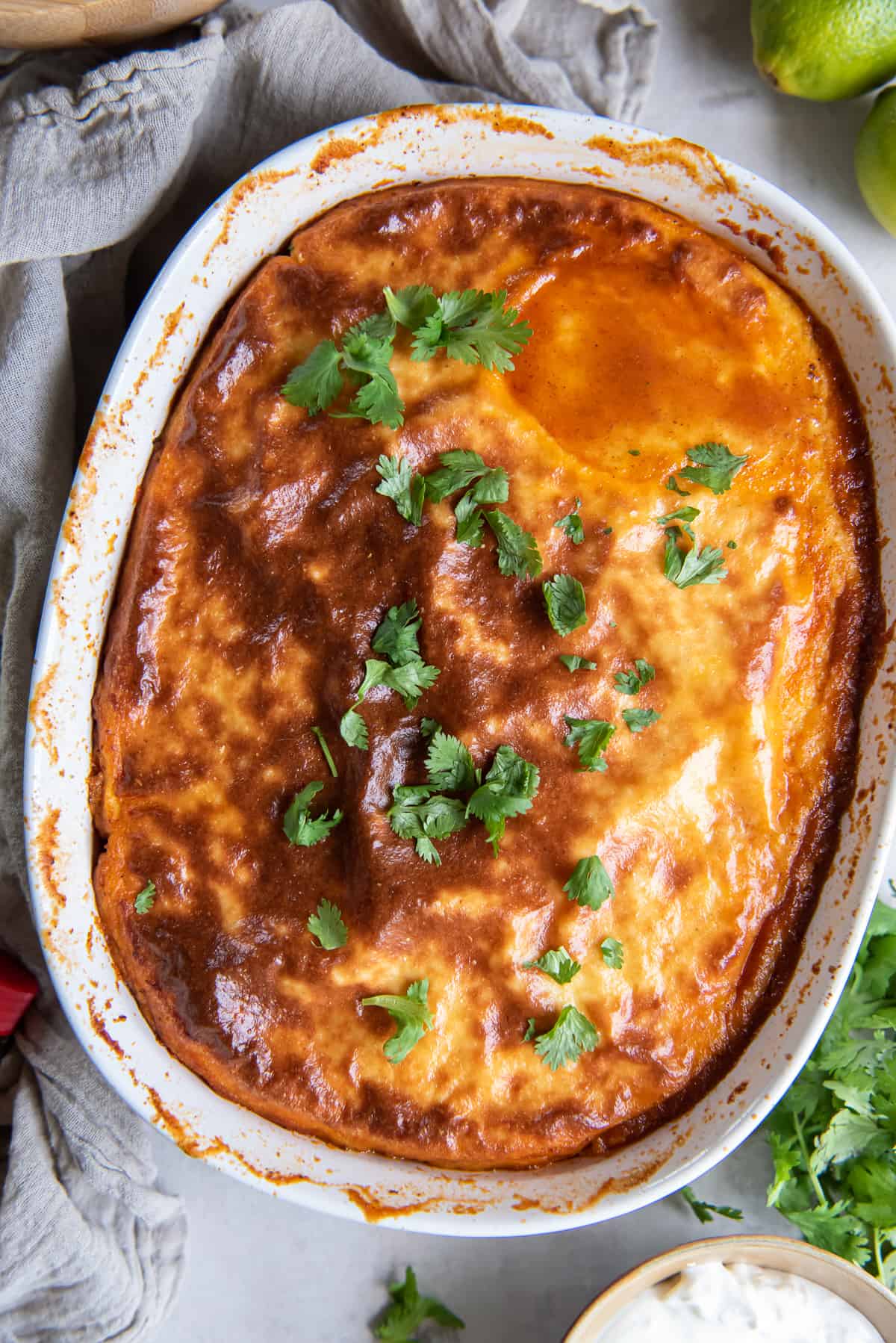 A top down shot of a browned cornmeal crust on tamale pie in a white casserole dish.