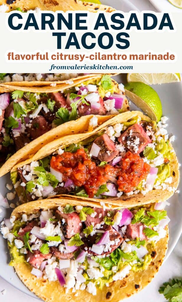 Carne asada tacos with toppings on a platter with text.