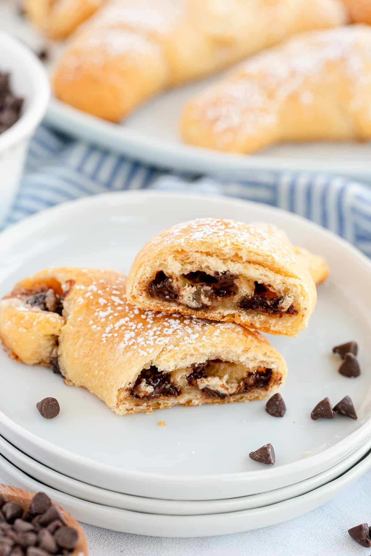 A chocolate crescent cut in half and stacked on a white plate.