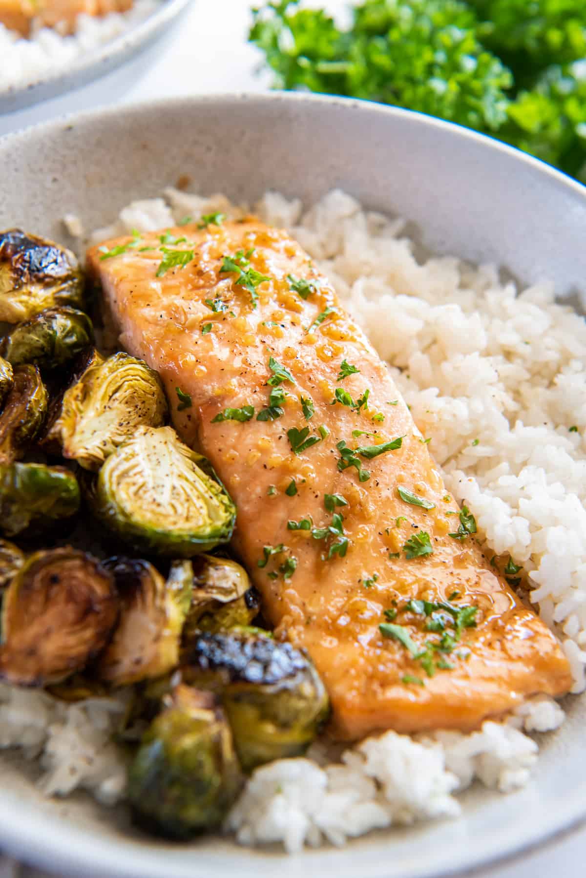 Maple glazed salmon in a bowl with rice and brussels sprouts.