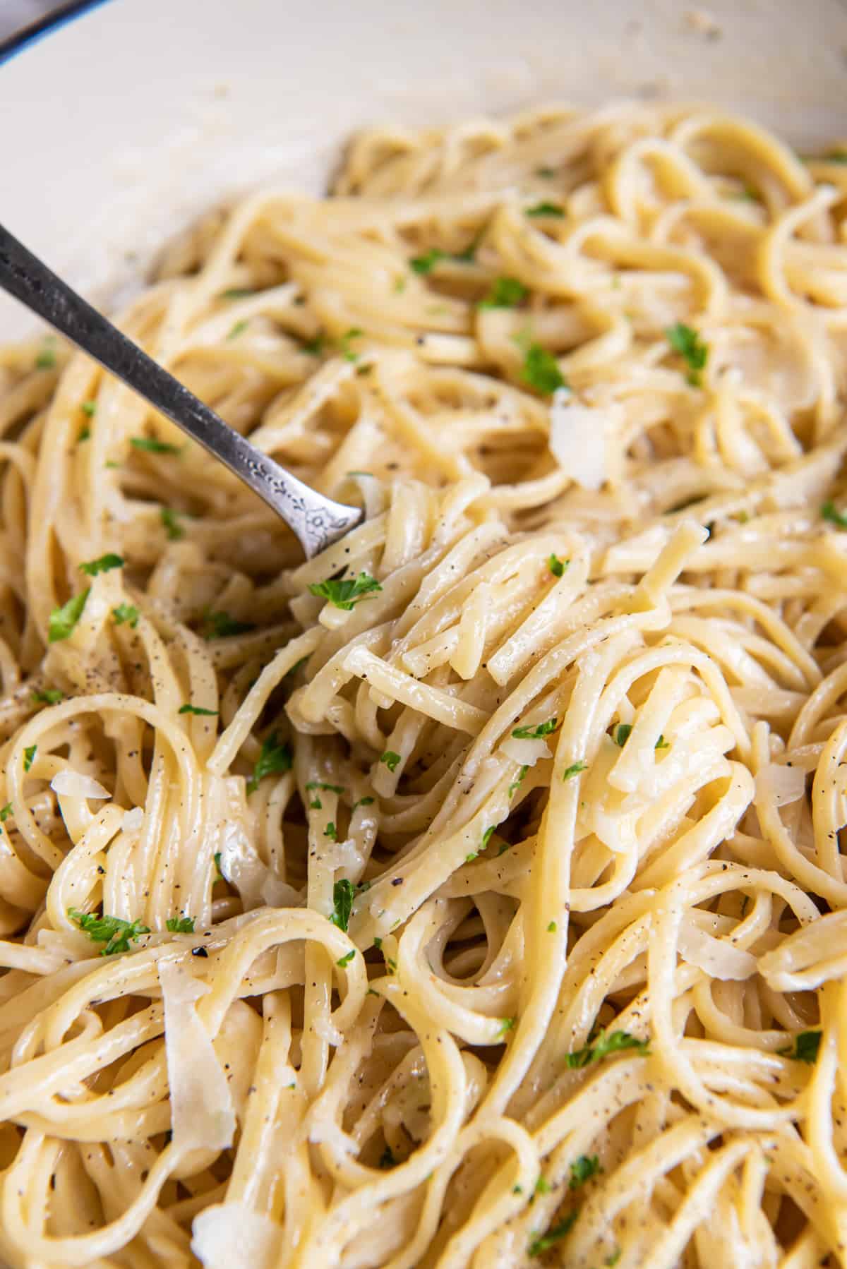 Linguine with Parmesan twirled around a fork.