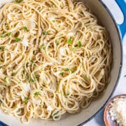 Parmesan Noodles in a blue skillet next to a small bowl of Parmesan.