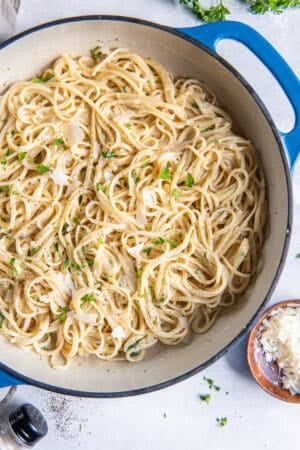 Parmesan Noodles in a blue skillet next to a small bowl of Parmesan.