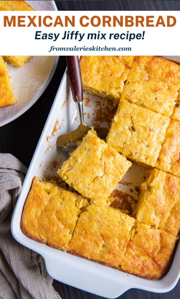 A spatula lying in a baking dish full of sliced cornbread with text.