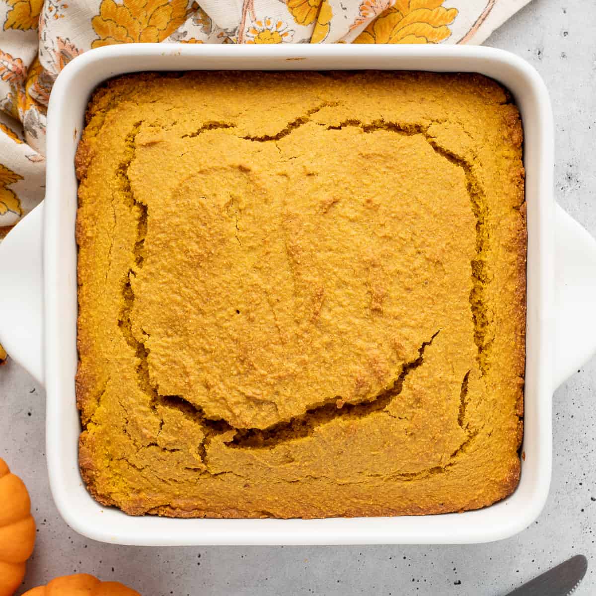 A top down shot of pumpkin cornbread in a white baking dish.