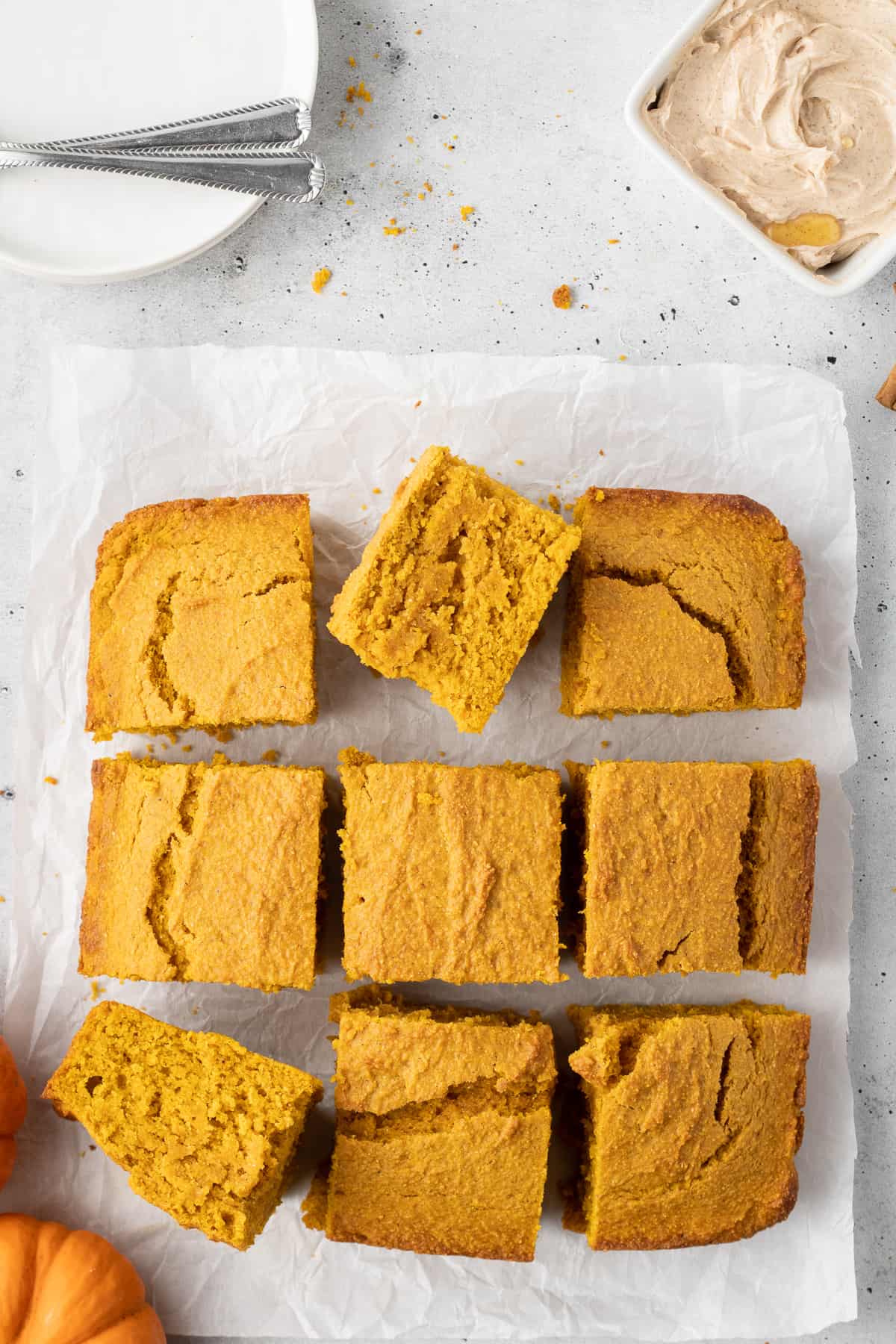A top down shot of slices of pumpkin cornbread on a piece of parchment paper.