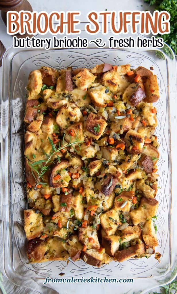 A top down shot of stuffing made with brioche in a glass baking dish surrounded by fresh herbs with text.