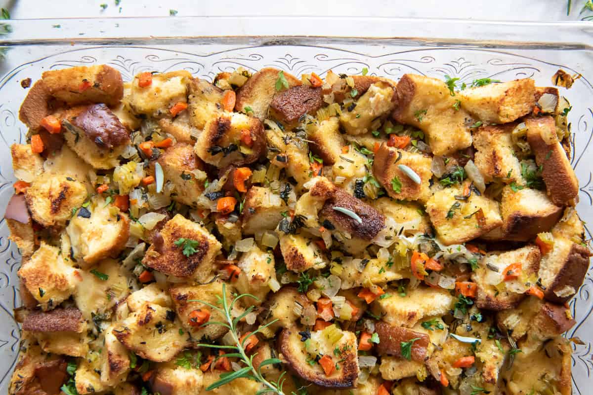 A close up top down shot of stuffing made with brioche in a glass baking dish.