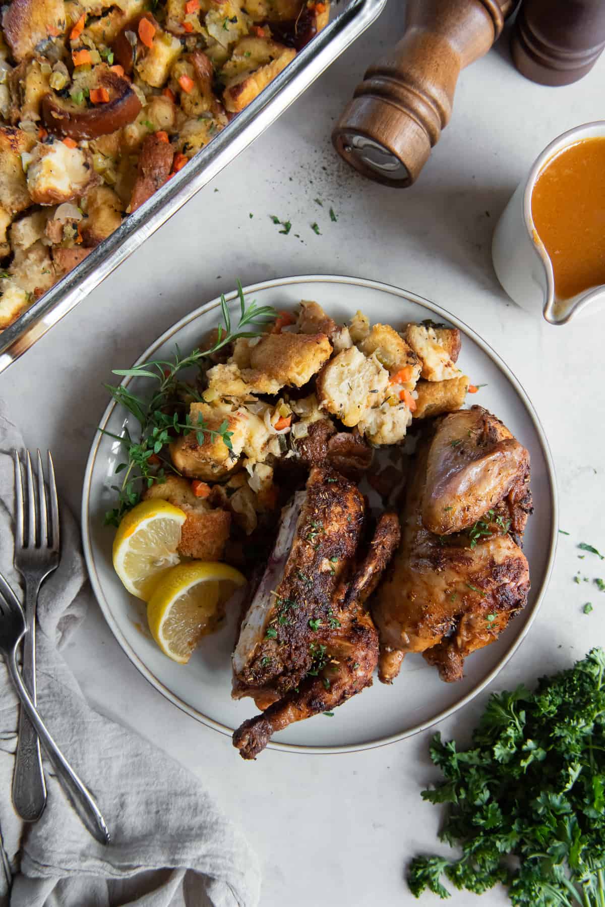 A cornish game hen sliced in half on a plate with stuffing.