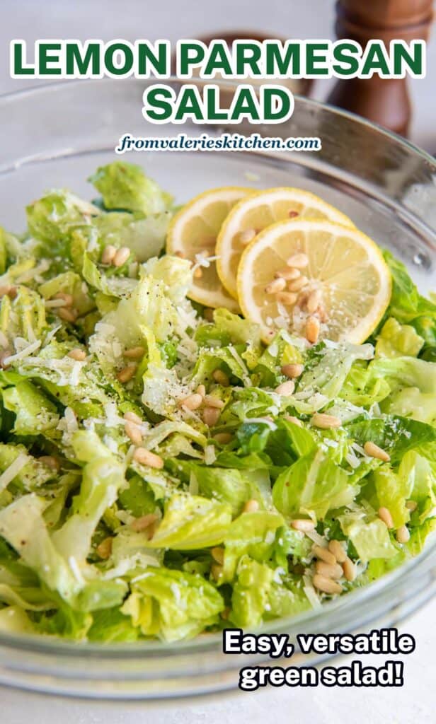 A salad of chopped romaine with Parmesan cheese and pine nuts garnished with lemon slices with text.