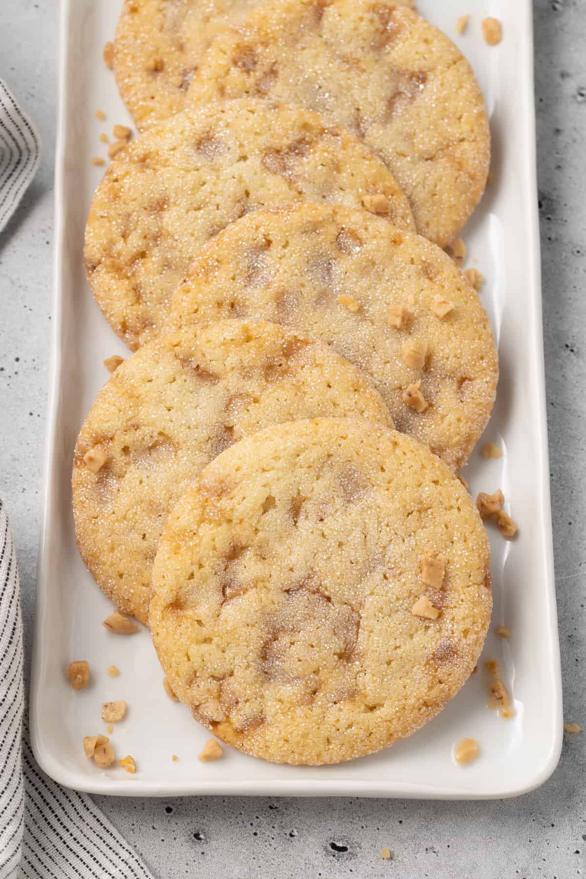 A row of Butter Toffee Cookies on a narrow white platter.